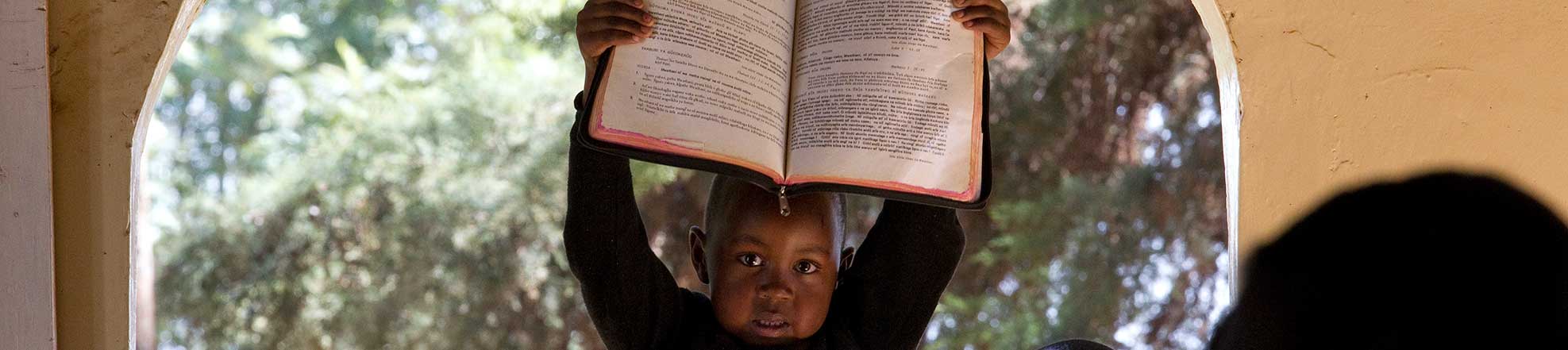 child holding up a book