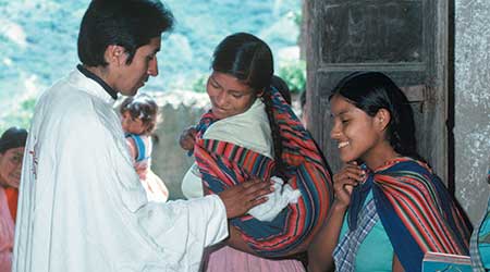 mother with a baby and a priest