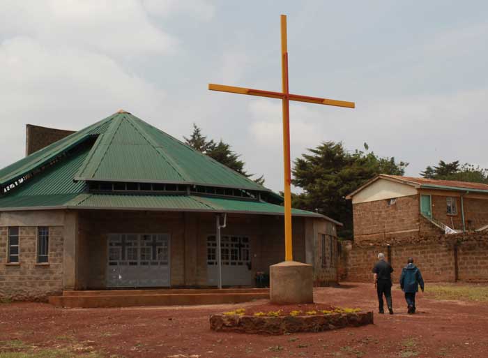 priest and a man walking by a church in Africa