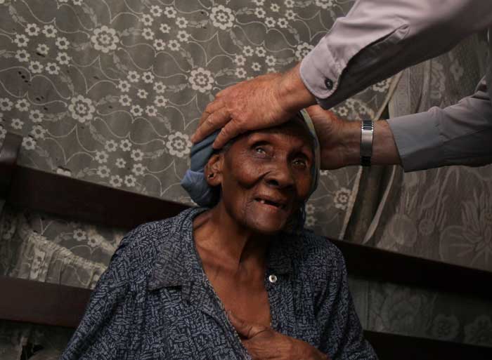 a woman with priests hands on her head