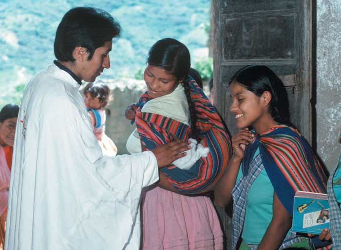 mother with a baby and a priest