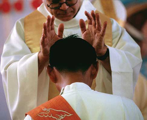 priest with his hands over man's head